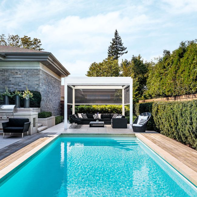 Un espace extérieur élégant et fonctionnel avec pergola bioclimatique et toiles motorisées conçu par Exosystème.